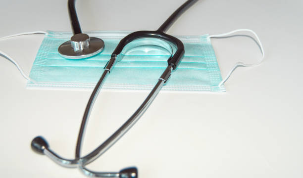istock Medical protective mask and stethoscope on a white table in the doctor's office, close-up 1293671376