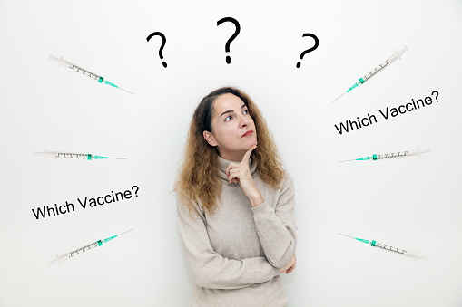 A woman with syringes around her thinking with serious face about question and doubts with hand on chin, thoughtful, confusing.