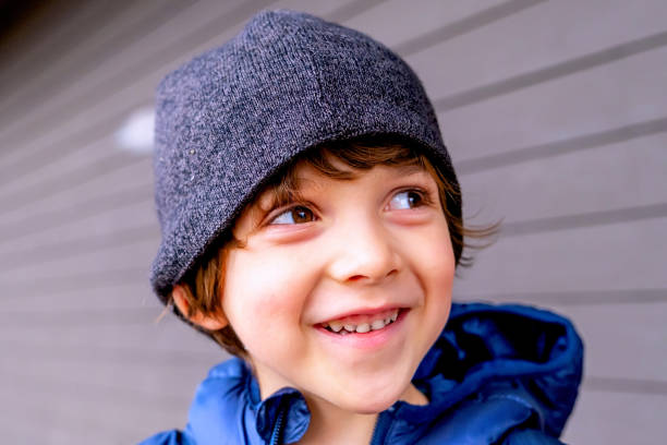 Caucasian Smiling pensive little boy looking away wearing a knit hat