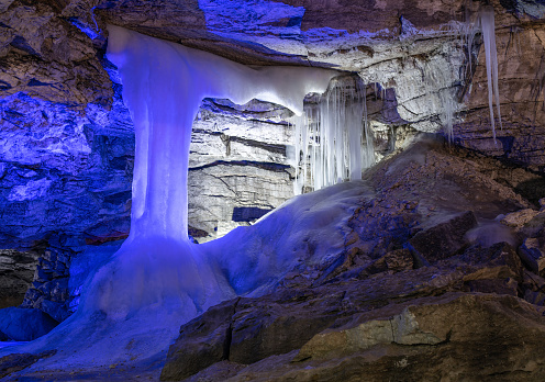 Entrance to ice cave with plenty of icicles. Slope of the mountain inside a fantastic cave. Kungur In The Urals, Russia
