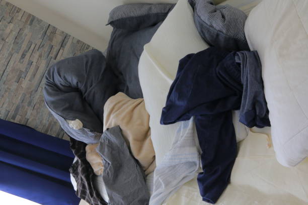 istock Beds, duvets and pillows in a dirty room with messy clothes 1293680496