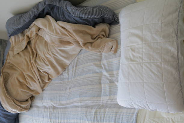 istock Beds, duvets and pillows in a dirty room with messy clothes 1293681139