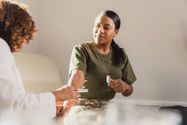 istock Female solider watches as unrecognizable doctor examines her arm 1293681754