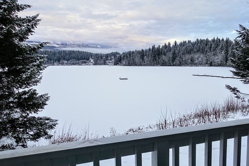 A beautiful winter landscape view overlooking a lake covered in snow.  The view is from a balcony in Clearwater, British Columbia, Canada