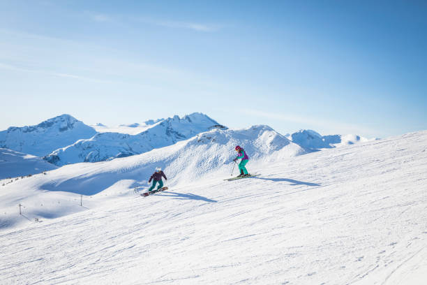 esquiadora e snowboarder andando juntas na montanha whistler. - skiing snow skiing helmet fun - fotografias e filmes do acervo