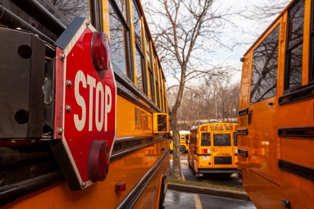 un'immagine ravvicinata dello scuolabus giallo americano con focus selettivo sul cartello di stop sul lato. - school bus defocused education bus foto e immagini stock