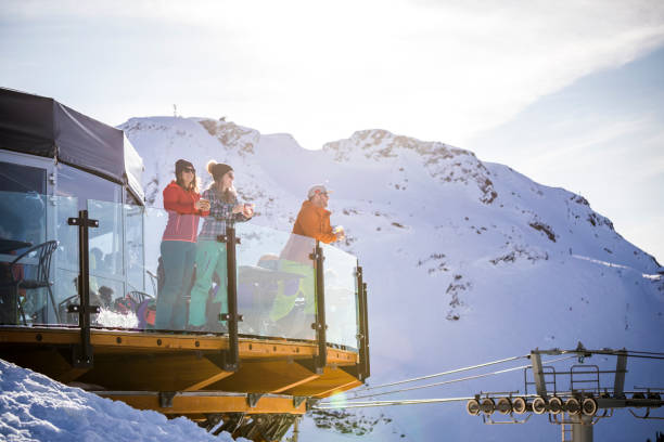 Group of friends enjoying apres-ski at top of Whistler mountain. Skiers having drinks at the top during their ski  vacation in Whistler, Canada. whistler mountain stock pictures, royalty-free photos & images