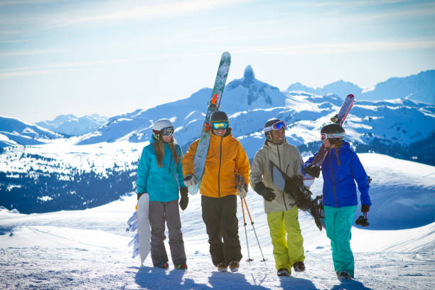 Group of friends skiing and snowboarding at Whistler Blackcomb ski resort. Beautiful sunny day in Whistler ski resort with skiers and snowboarder enjoying snow. whistler skiing stock pictures, royalty-free photos & images