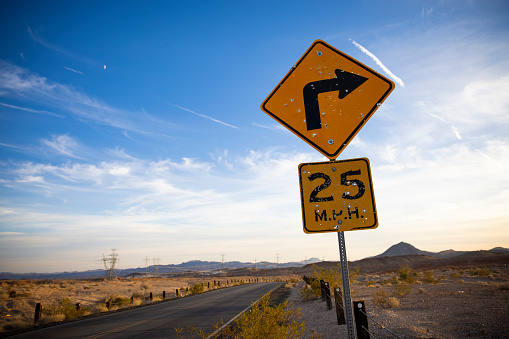A road sign in the Nevada desert with bullet holes.