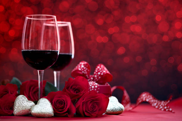 istock Valentine's Day Red Roses and Red Wine with a Gift on a Defocused Lights Background 1293698132