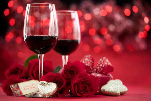 istock Valentine's Day Red Roses and Red Wine with a Gift on a Defocused Lights Background 1293698138