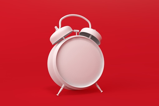 Old alarm clock on red background