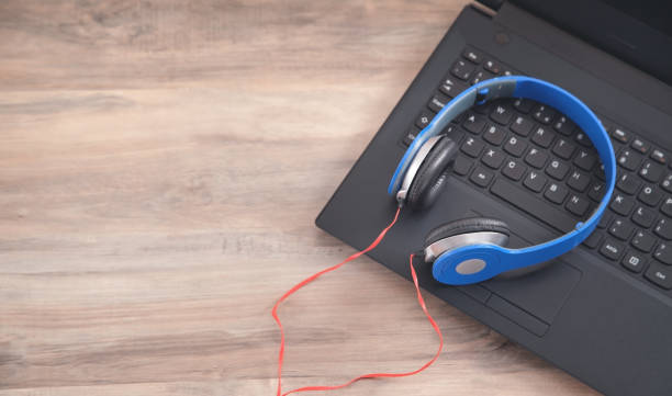 istock Blue headphones on the computer keyboard. 1293705814