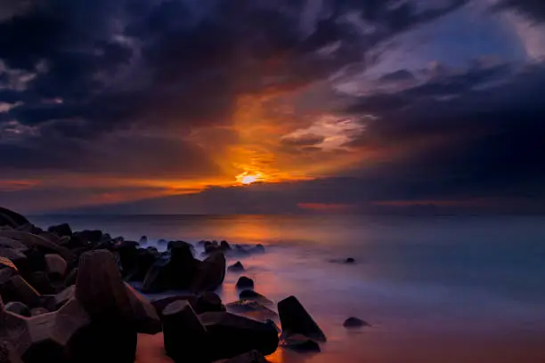 Beautiful sunset over the sea. sky on twilight time and reflection on the sea for travel on holiday relax time. Rock on the seashore and cloudy sky. Long exposure shot. Kanyakumari, Tamil Nadu, India