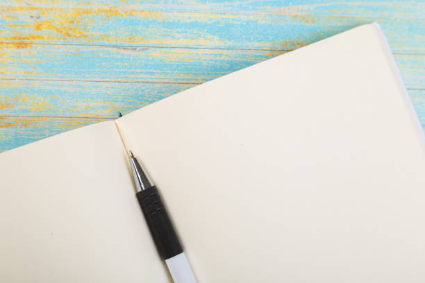 istock school colored notepads with ballpoint pen on blue wooden background 1293710324