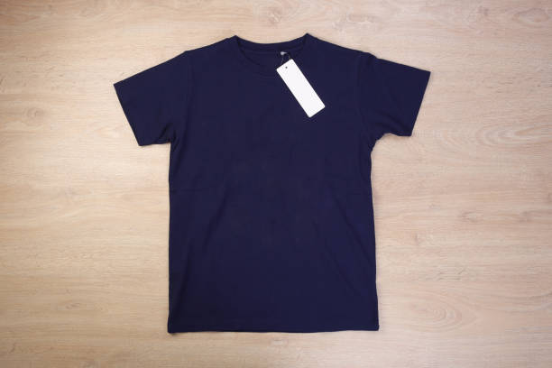 istock Front navy blue tshirt with label on wooden background 1293712710