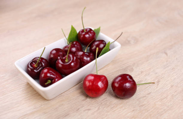 istock Fresh cherry in white bowl and on wooden background 1293712812