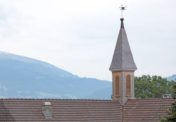 Ancient small church tower, mountains in the background