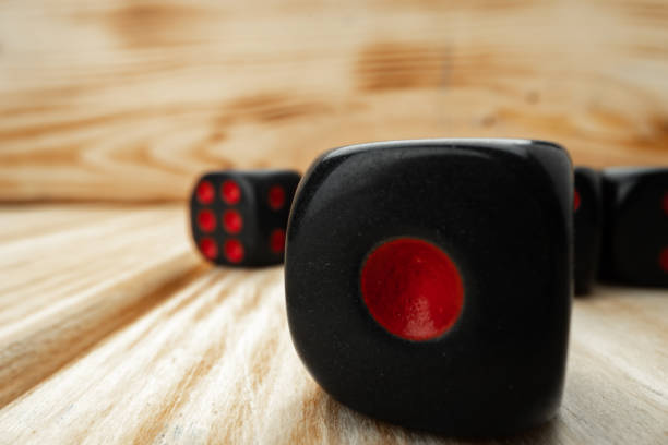 istock Macro of black tossed dice on wooden background 1293718430