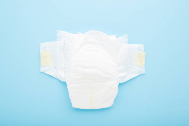 istock White, soft, new baby diaper on light blue table background. Pastel color. Closeup. Top down view. 1293719867