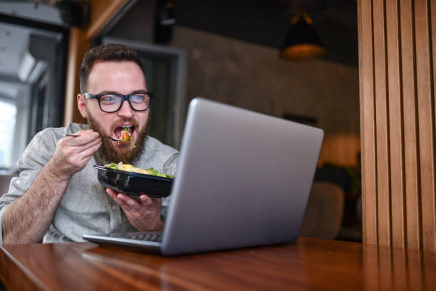 Lunch Time For Male During Laptop Video Conference Lunch Time For Male During Laptop Video Conference caesar salad food salad tuna stock pictures, royalty-free photos & images