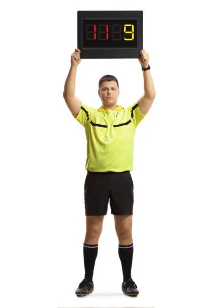 Full length portrait of football referee holding a substitute board isolated on white background