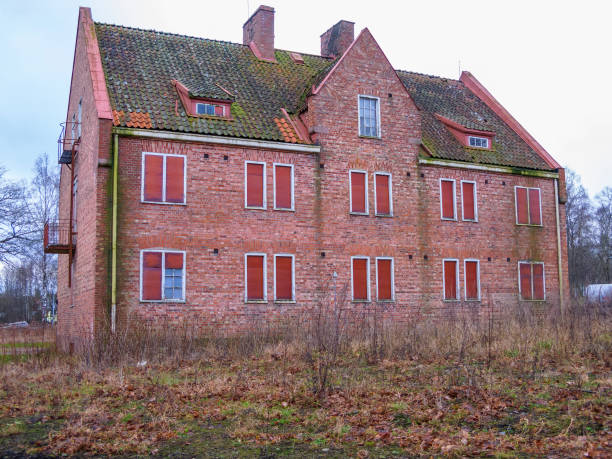 Large old house on a gloomy day in Astoria, WA. The house is constructed of wood with a brick chimney.