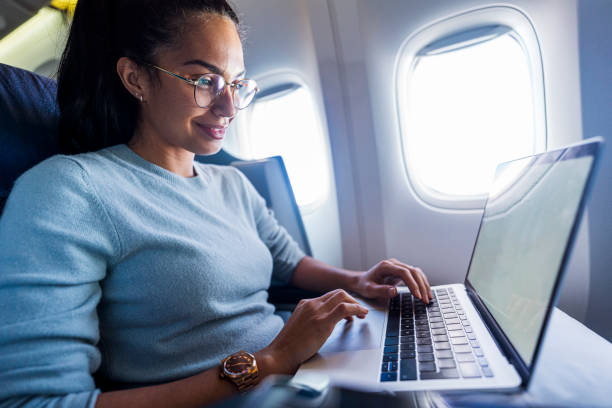 istock Beautiful business woman in a plane working on laptop 1293726310