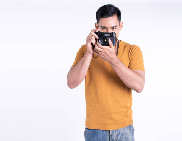 istock Asian man holding camera for traveling and standing on white background 1293726623