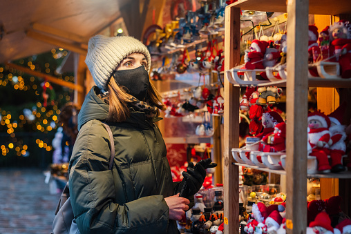 Woman in face mask on Christmas shopping