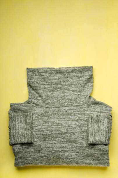 istock Vertical image.Top view of trendy grey sweater on the yellow background.Empty space 1293729955