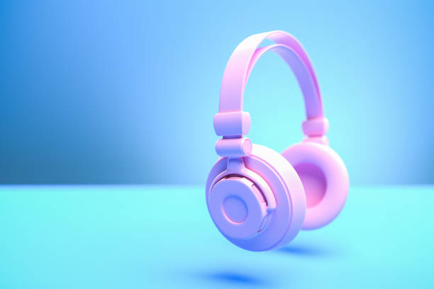 istock Music concept: A pink headphone against a blue background with shadow. Copy space - selective focus on foreground 1293738275