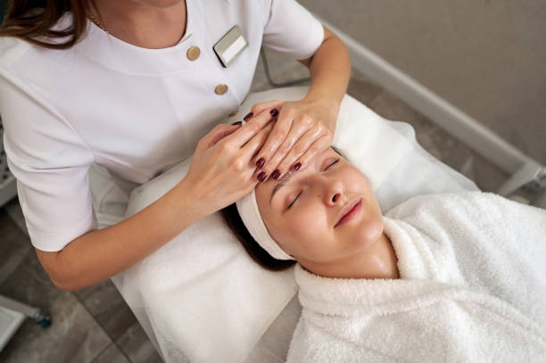 portrait of beautiful young woman enjoying face lifting massage in spa salon - massage therapist massaging sport beautician imagens e fotografias de stock