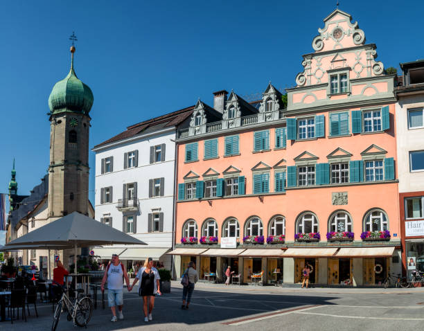 People walking around the rathaus square near chapel of saint george and hilarius in the austrian city bregenz. BREGENZ, AUSTRIA, JUNE 15, 2019: People walking around the rathaus square near chapel of saint george and hilarius in the austrian city bregenz. bregenz stock pictures, royalty-free photos & images
