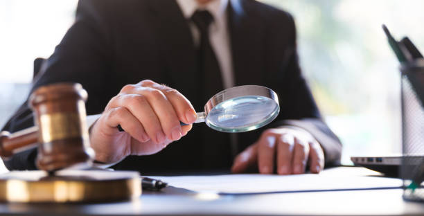 istock Man In Black Suit Reading A Legal Document Carefully Using Magnifying Glass 1293740174