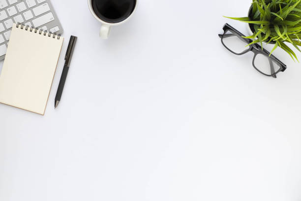 istock Top view above of White office desk table with keyboard, notebook and coffee cup with equipment other office supplies. Business and finance concept. Workplace, Flat lay with blank copy space. 1293740216