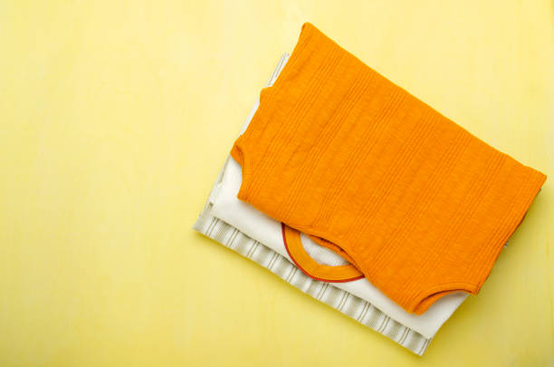 istock Top view of colorful stack of clothes for summer on the yellow background.Empty space 1293747637