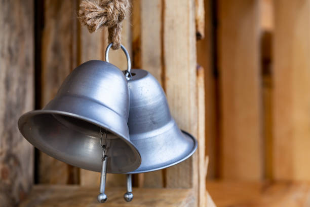 istock Two large, silver, decorative bells hanging inside wooden boxes 1293750058