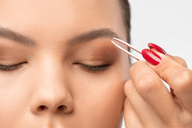 istock Makeup artist combs  and plucks eyebrows after dyeing in a beauty salon.Professional makeup and cosmetology skin care. 1293752920
