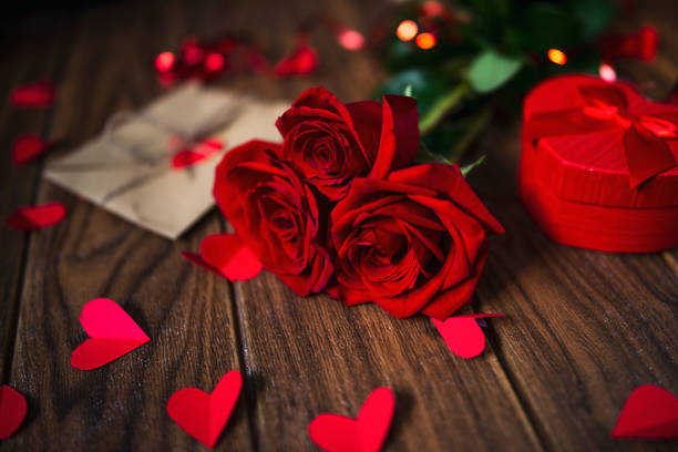 istock Valentine's Day Gift with Red Roses on a Dark Wood Background 1293756812