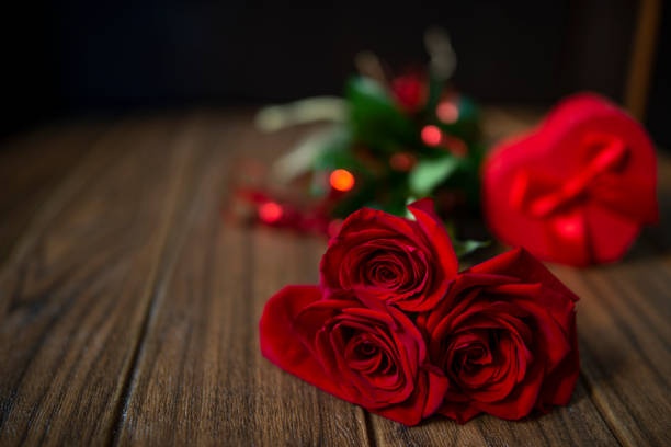 Valentine's Day Gift with Red Roses and envelope on a Dark Wood Background
