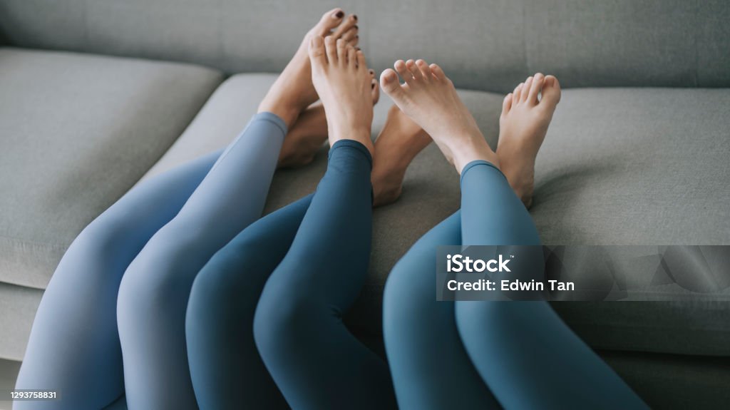Asian Chinese Legs With Yoga Pants Resting On Sofa Stock Photo