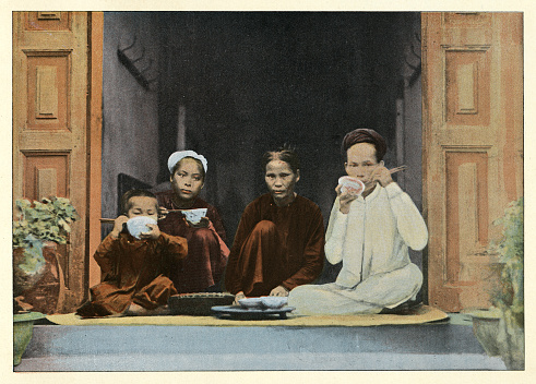 Vintage colourised photograph of an Annamite family at meal, Annam (Vietnam), Victorian 19th Century