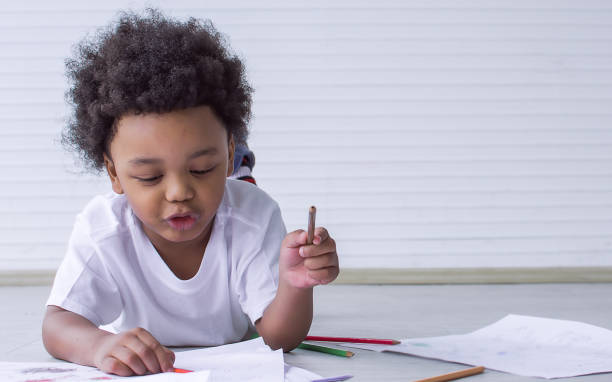 istock Little african boy is drawing and painting 1293763300