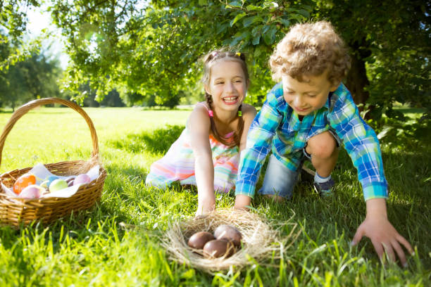 istock Cute boy and girl celebrating Easter, searching and eating chocolate eggs 1293765300