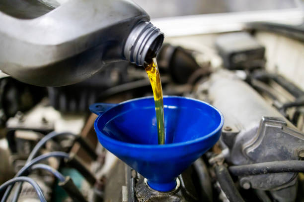 istock technician worker pouring engine oil. car maintenance at service station or workshop. selective focus 1293765344