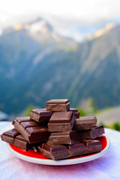 istock Handmade pure dark swiss chocolate and Alpine mountains on background 1293766429