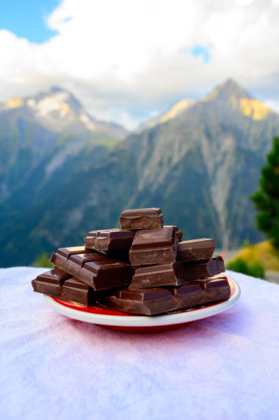 istock Handmade pure dark swiss chocolate and Alpine mountains on background 1293766433