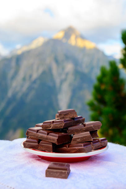 istock Handmade pure dark swiss chocolate and Alpine mountains on background 1293766441