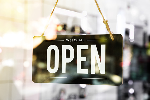 Open sign board hang on glass of door  in cafe